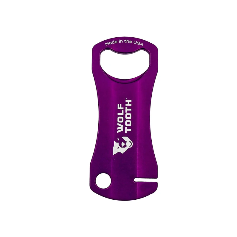 Fioletowy klucz Wolf Tooth Components do prostowania tarcz hamulcowych z funkcją otwieracza do butelek.
